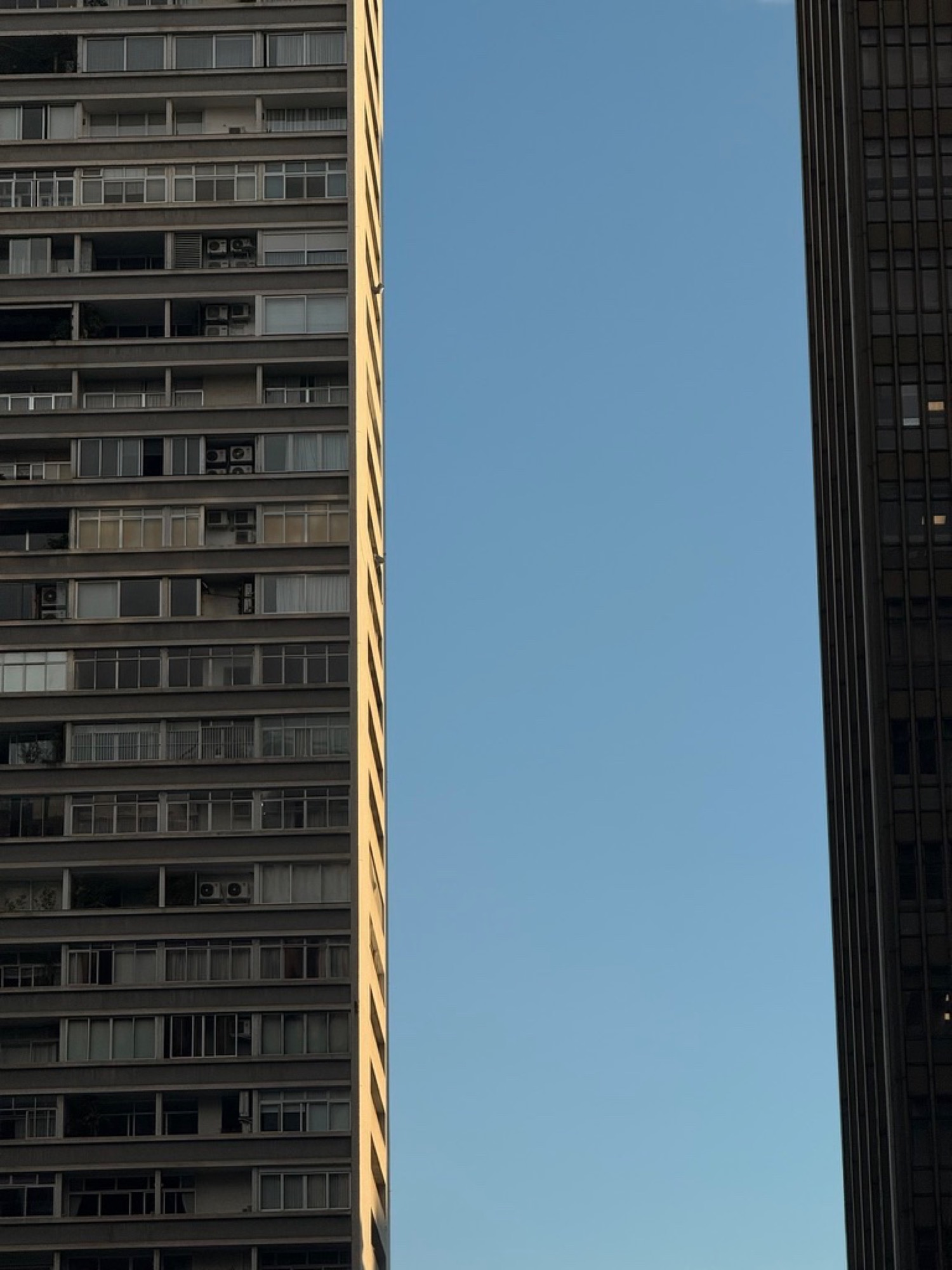 Two towers with a slice of sky between them