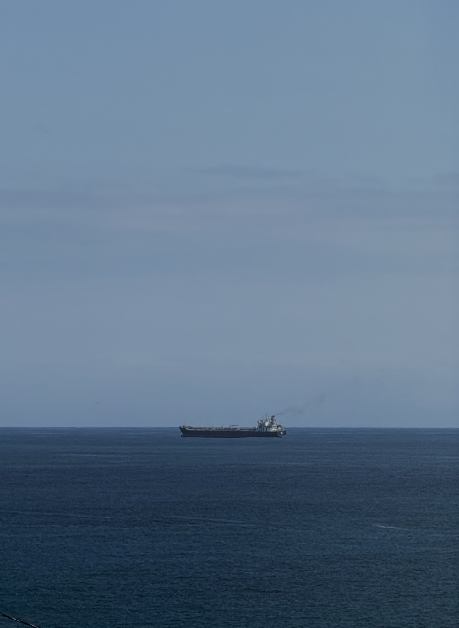 A lone cargo ship on the horizon